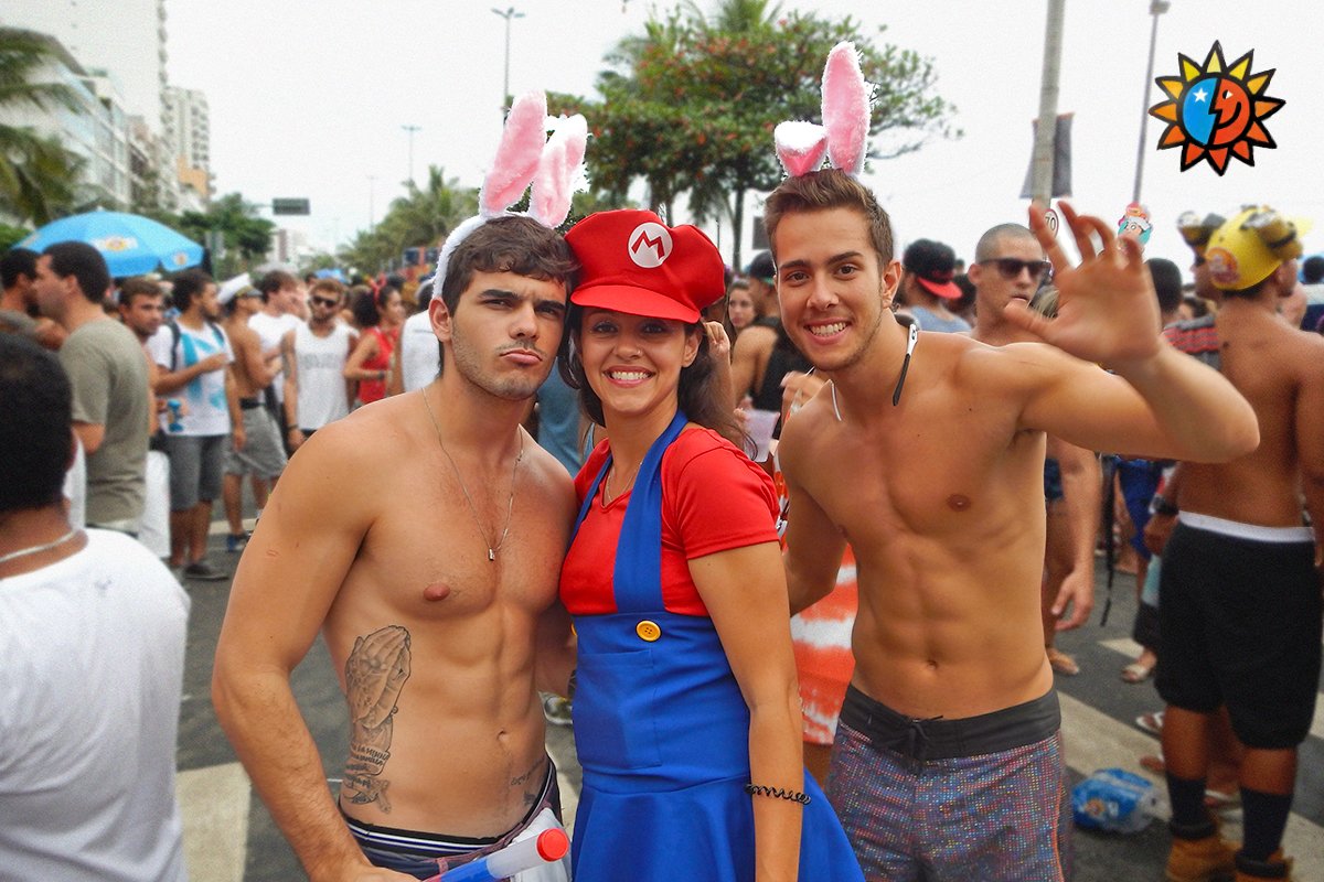 Three Cariocas enjoying street festivities in Ipanema. The girl is dressed up as the character Mario, and the two boys are shirtless wearing pink bunny ears.
